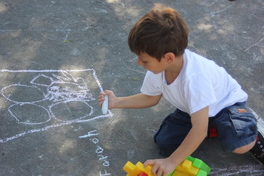 child drawing with chalk